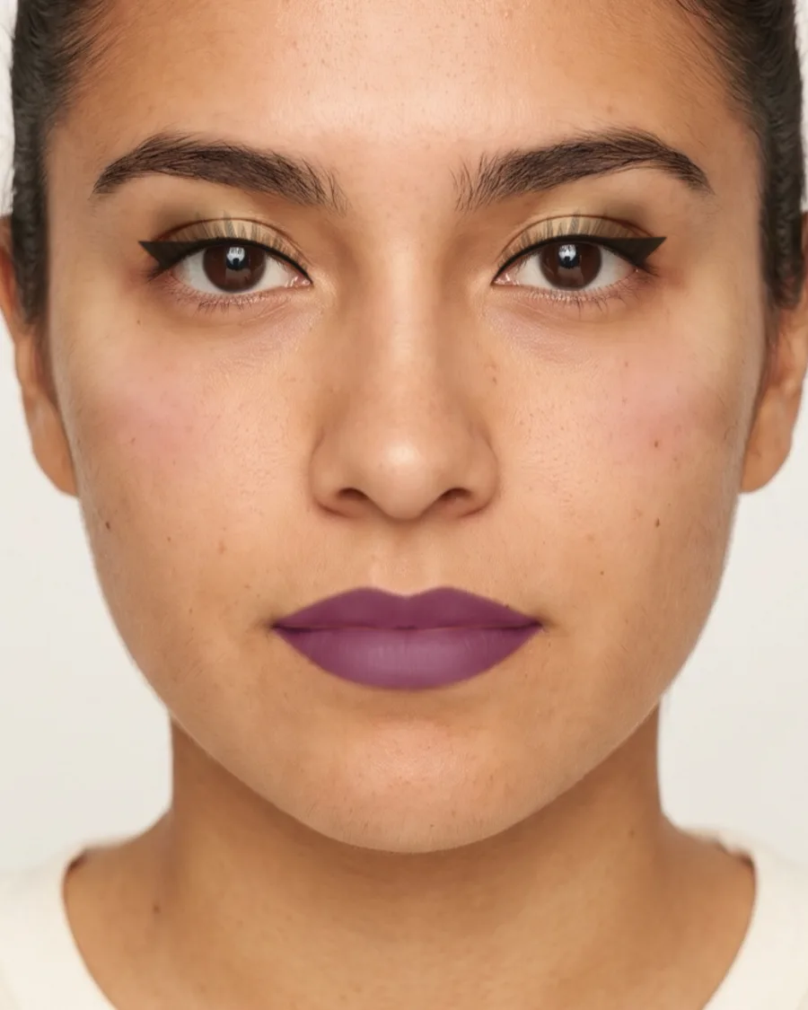 Prom makeup for a purple dress: A pale gold lid, a soft brown crease and a plum lip. Shown on an AI model.